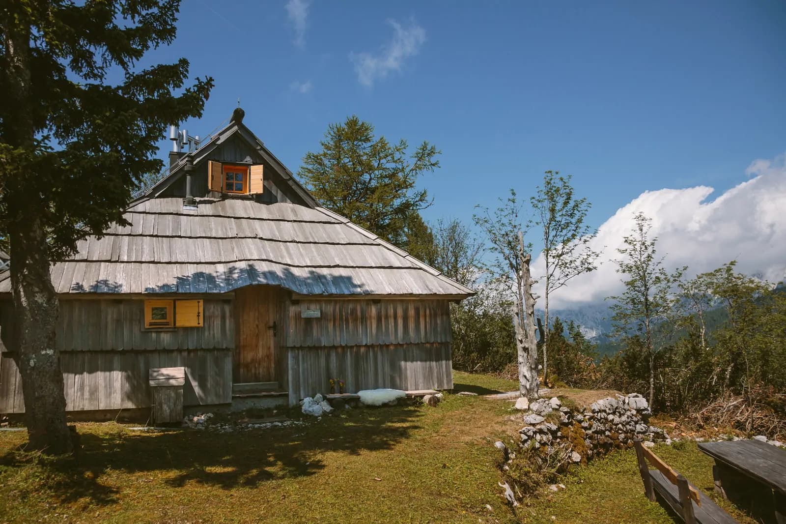Chalet Orlica en un prado de Velika Planina, con vistas abiertas a los valles y al cielo azul